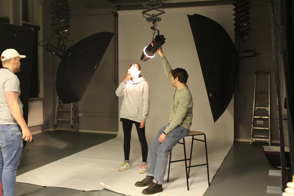 Student setting up photography studio equipment