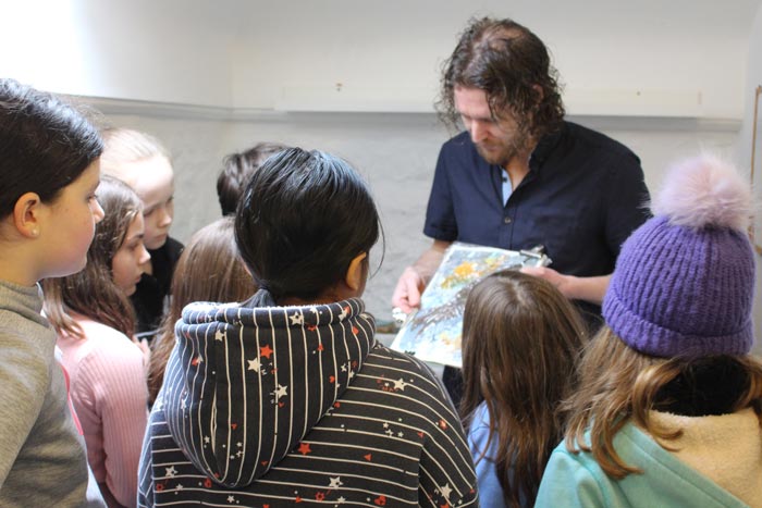 Teacher showing a drawing to class